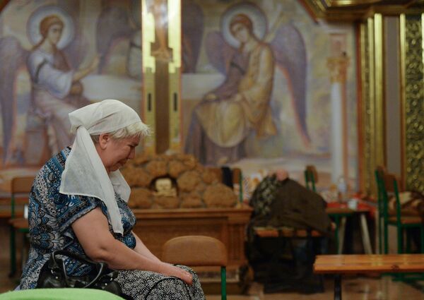 Se escondían de los bombardeos no sólo en los sótanos, sino también en las iglesias. En la foto: una habitante de Górlovka que huye de los bombardeos del ejército ucraniano en la Iglesia de la Epifanía. Julio de 2014. - Sputnik Mundo