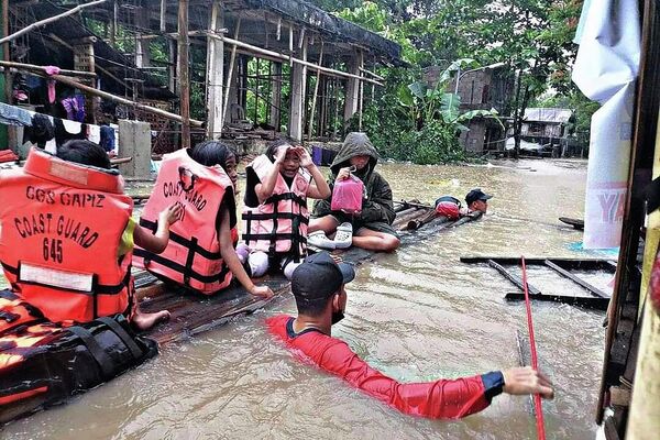 Los equipos de rescate evacuan a los residentes de una aldea inundada en Panitan (Filipinas). Las fuertes lluvias provocadas por una depresión tropical estival han matado al menos a varias personas en la zona central de la isla. - Sputnik Mundo