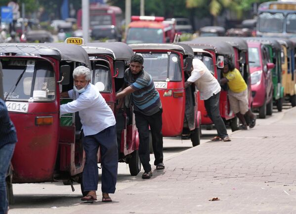 Varios conductores de autos rickshaws (vehículos triciclos motorizados) en Sri Lanka hacen filas para comprar gasolina frente a una estación en la ciudad de Colombo. - Sputnik Mundo
