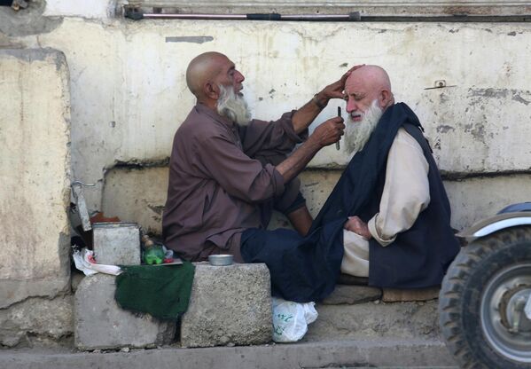 Un hombre en una barbería callejera en la ciudad de Peshawar, Pakistán. - Sputnik Mundo