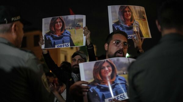 Los manifestantes sostienen fotos de la periodista de Al Jazeera, Shirin Abu Akleh - Sputnik Mundo