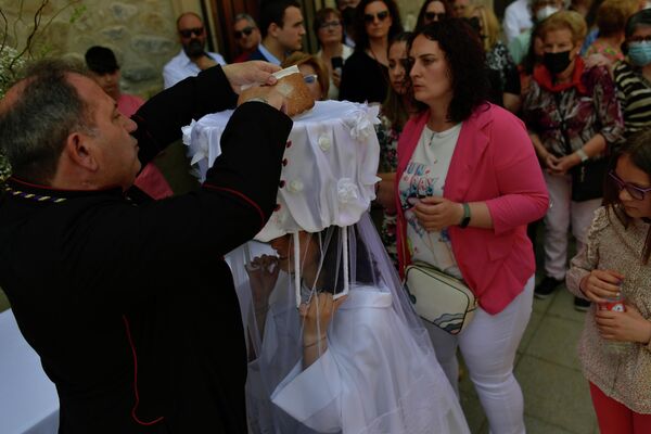Un sacerdote pone pan en la cesta de una de &#x27;las Doncellas&#x27; durante la fiesta en honor a Santo Domingo de La Calzada en la antigua ciudad del norte de España que lleva su nombre. - Sputnik Mundo