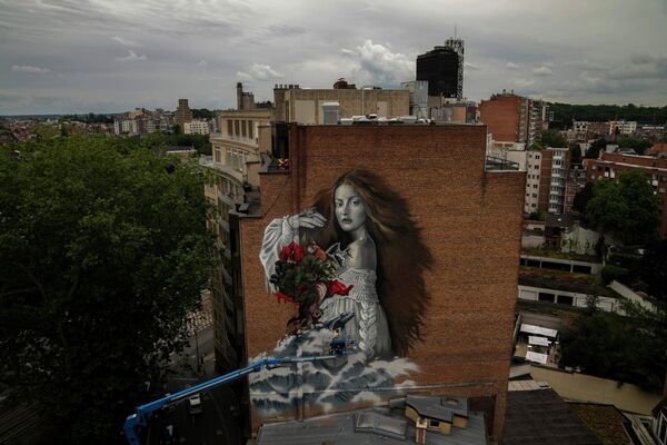 La artista callejera española Lula Goce trabajando en un grafiti gigante que representa a la madre naturaleza en Bruselas (Bélgica) como parte del proyecto mundial de la ONG Street Art for Mankind, 12 de julio de 2021. - Sputnik Mundo