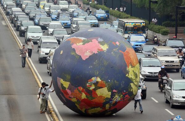 Activistas hacen rodar un enorme globo terráqueo inflable durante la manifestación Limpiar el aire, salvar el clima en Yakarta (Indonesia) el 16 de noviembre de 2007, antes de la 13ª conferencia de la ONU sobre el cambio climático celebrada en ese país. - Sputnik Mundo