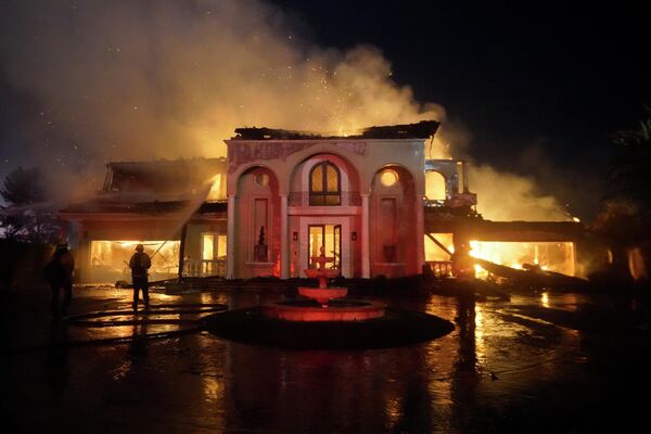 Los bomberos extinguen una mansión en llamas en el lujoso barrio de Laguna Niguel, en California, que se incendió a causa de un incendio forestal que se propagó a la ciudad. - Sputnik Mundo