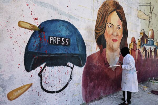Artistas palestinos pintan grafitis en la ciudad de Gaza en memoria de Shirin Abu Akleh, periodista de Al Jazeera que murió en un intercambio de fuego entre palestinos e israelíes en Cisjordania. - Sputnik Mundo