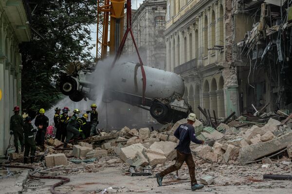 Los bomberos ponen agua en un camión cisterna antes de retirarlo del lugar de la explosión que destruyó el Hotel Saratoga en La Habana. - Sputnik Mundo