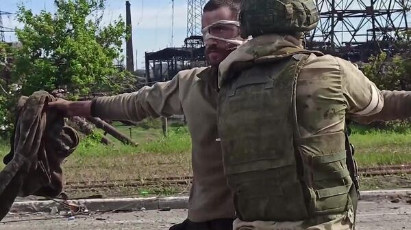 Un militar ruso examina a un soldado ucraniano que se rindió en la planta siderúrgica Azovstal en Mariúpol  - Sputnik Mundo