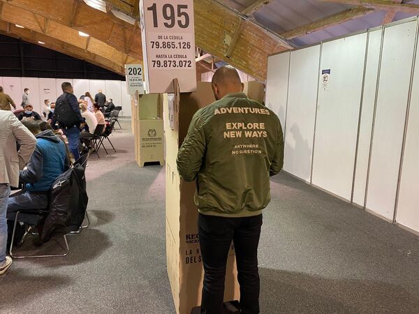 Un hombre votando en Corferias, el puesto de votación más grande del país. - Sputnik Mundo