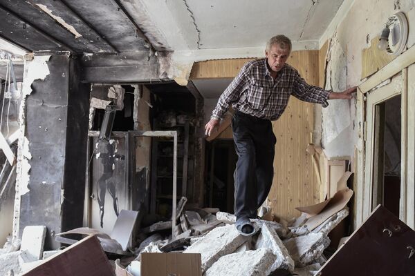 Mariupol necesita una seria reconstrucción tras los intensos combates.En la foto: un hombre dentro de un piso de una casa destruida en una calle de Mariúpol. - Sputnik Mundo
