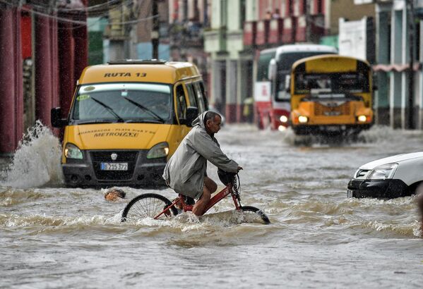 Un ciclista en una calle inundada a raíz de las fuertes lluvias en La Habana, Cuba. - Sputnik Mundo