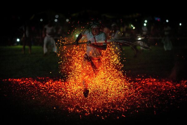Un sacerdote hindú camina sobre fuego durante una festividad celebrada en el poblado de Gamerimura, en la India. - Sputnik Mundo