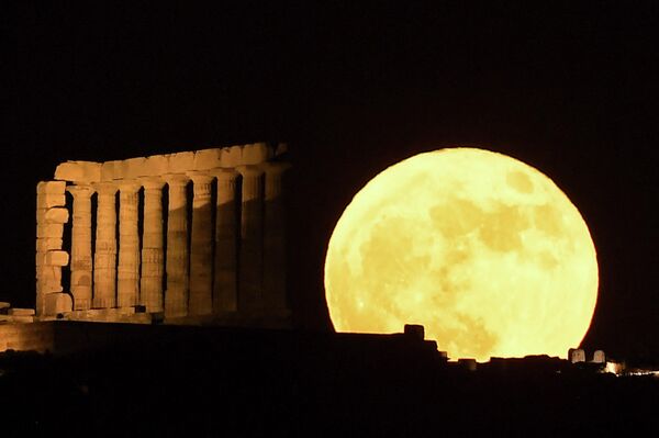 La luna de fresa detrás del templo de Poseidón en el cabo Sounion, Grecia. - Sputnik Mundo