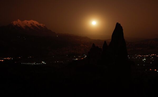 La luna de fresa cerca de la cima nevada de la montaña Illimani cerca de la ciudad de La Paz en Bolivia. - Sputnik Mundo