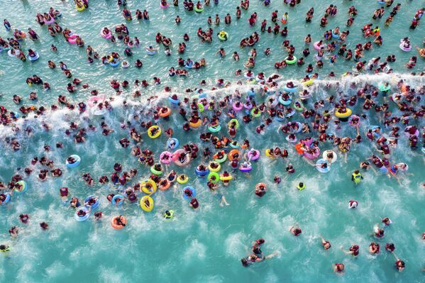 Personas nadan en la piscina de un parque acuático en Zhengzhou, provincia de Henan, China. - Sputnik Mundo