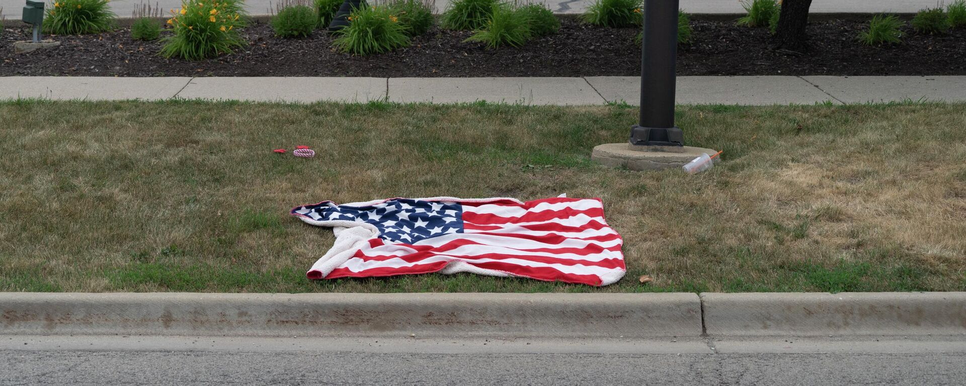 Una bandera estadounidense después del tiroteo ocurrido en Highland Park en el Día de la Independencia de EEUU, el 4 de julio de 2022 - Sputnik Mundo, 1920, 04.07.2022