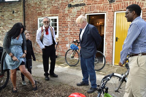 El primer ministro Boris Johnson y el diputado conservador Darren Henry (derecha) durante un encuentro con votantes en Beeston, Inglaterra. - Sputnik Mundo