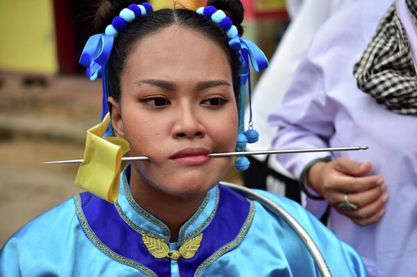 Los &#x27;piercings&#x27; se realizan sin anestesia. Para evitar sentir dolor, los participantes del desfile entran en un estado de trance. En la foto: una participante en el desfile dedicado a la diosa del templo Gow Lengchi en Narathiwat, al sur de Tailandia. - Sputnik Mundo