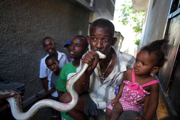 Un residente de Petionville, Haití, besa una serpiente durante el carnaval antes de la Cuaresma para atraer la buena suerte. - Sputnik Mundo