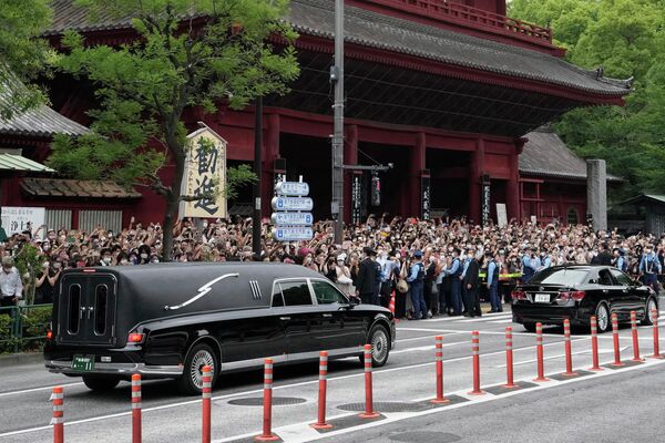 Un coche fúnebre que transporta el cuerpo del ex primer ministro japonés Shinzo Abe sale del santuario de Zojoji en Tokio tras una ceremonia de despedida y se dirige a un lugar de cremación. - Sputnik Mundo