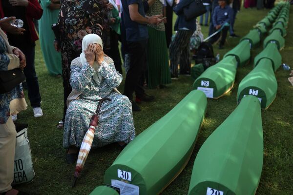 Una mujer bosnia junto al féretro con los restos de su marido, identificado entre otras 50 víctimas de la tragedia de Srebrenica, en el 27 aniversario del suceso en Potocari, Bosnia y Herzegovina. - Sputnik Mundo