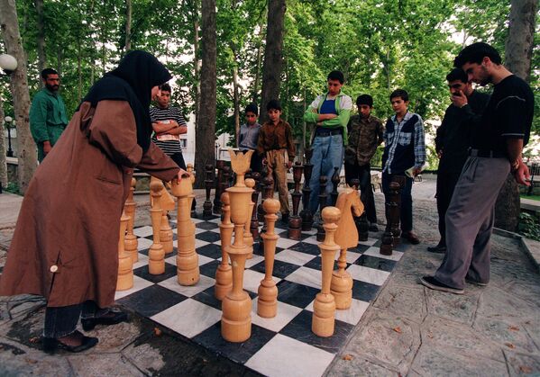 A pesar de la oposición de la religión islámica y de la Iglesia cristiana, el ajedrez se convirtió en uno de los juegos más populares.
En la foto: una niña iraní juega una partida de ajedrez en un parque de Teherán, 1997.
 - Sputnik Mundo