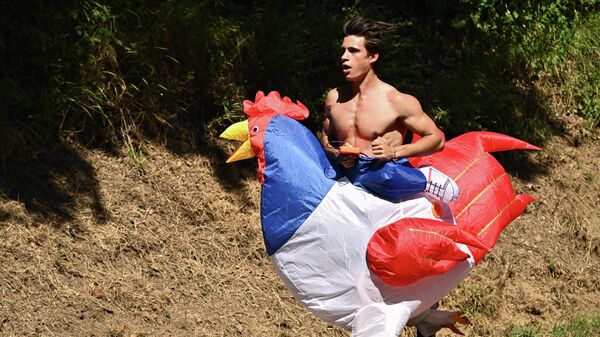 Un aficionado disfrazado de pollo corre a lo largo del recorrido de la 15ª etapa del Tour de Francia entre Rodez y Carcassonne, al sur de Francia. - Sputnik Mundo