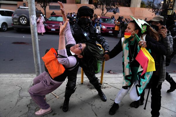 Una mujer policía intenta alejar a una manifestante de una participante progubernamental en La Paz, Bolivia. - Sputnik Mundo