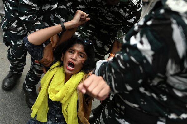 Agentes de seguridad detienen a una manifestante en Nueva Delhi, la India, durante una protesta realizada después de que al menos 30 personas murieran presuntamente por el consumo de licor espurio. 27 de julio del 2022. - Sputnik Mundo