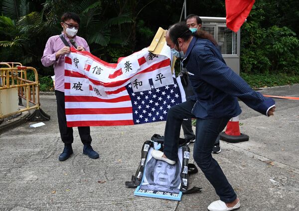 Un manifestante pro-Pekín pisotea una imagen que representa a la presidenta de la Cámara de Representantes de Estados Unidos, Nancy Pelosi, en una protesta frente al Consulado estadounidense en Hong Kong, el 3 de agosto de 2022. Esto ocurrió un día después de que Pelosi llegara a Taiwán como parte de una gira por Asia que agudizó las tensiones entre Estados Unidos y China. - Sputnik Mundo