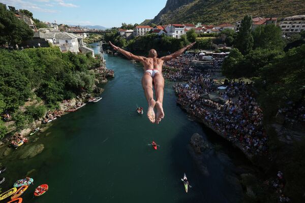 Un clavadista salta desde el Puente Viejo durante la 456ª competición anual de saltos de altura en Mostar, Bosnia. El 31 de julio de 2022, un total de 31 clavadistas de Bosnia y de la región saltaron desde dicho puente de 23 metros de altura al río Neretva. - Sputnik Mundo