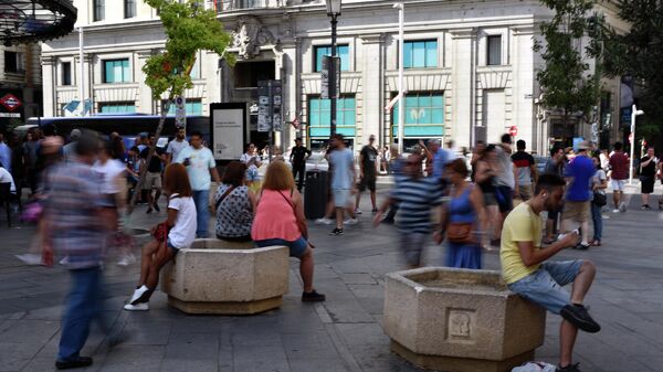 Gente está en la calle cerca de la Gran Vía en Madrid  - Sputnik Mundo