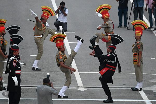 Rangers paquistaníes (de negro) y soldados de la Fuerza de Seguridad Fronteriza de la India (de caqui) durante una ceremonia de conmemoración del 75 aniversario de la independencia de la India en el puesto fronterizo de Wagah, a 35 km de Lahore, Pakistán. - Sputnik Mundo
