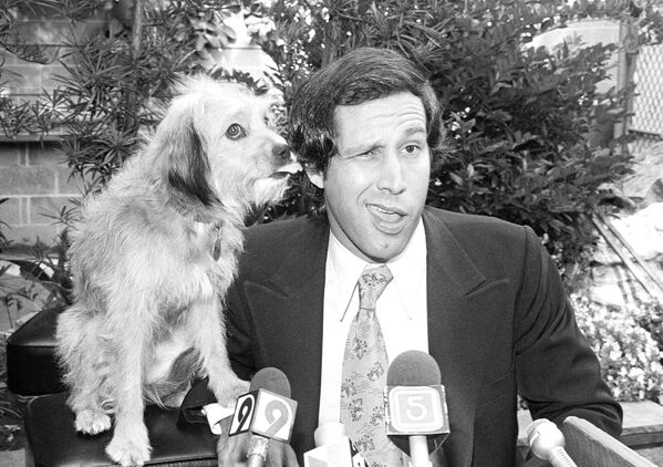 El actor de comedia estadounidense Chevy Chase con su compañero en la película El perro celestial, apodado Benji, en una conferencia de prensa en Los Ángeles, en 1979. - Sputnik Mundo