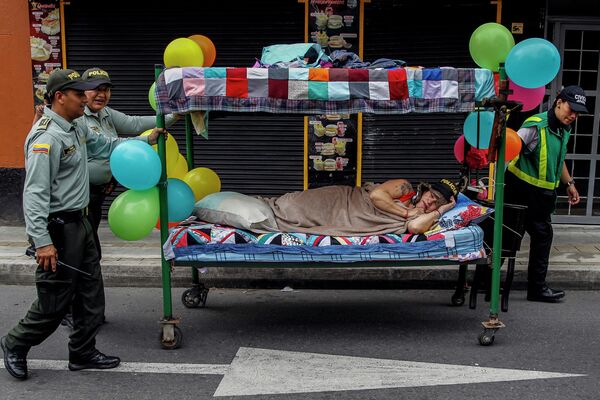 Policías empujan una cama mientras la gente celebra el Día Mundial de la Pereza en Itagüí, Colombia. - Sputnik Mundo