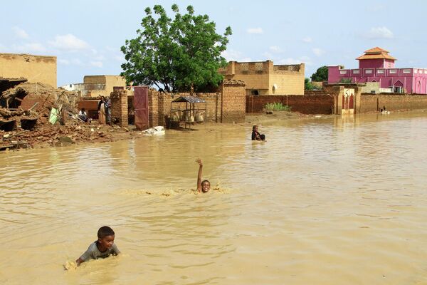 Unos niños juegan en una calle inundada de la ciudad de Iboud, en Sudán. - Sputnik Mundo