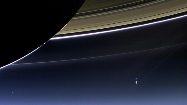 Así se ven la Tierra y la Luna (abajo a la derecha) desde la órbita de Saturno. La foto fue tomada en julio de 2013 por la sonda espacial Cassini. - Sputnik Mundo