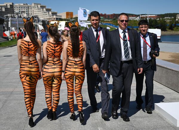 Participantes del Foro Económico Oriental y chicas jóvenes disfrazadas de tigres. - Sputnik Mundo