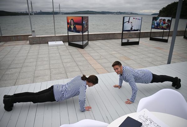 Jóvenes hacen flexiones frente al pabellón del Ministerio de Deportes en el foro. - Sputnik Mundo