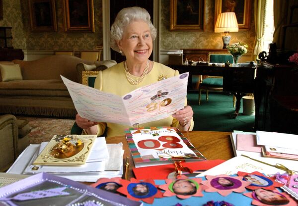 Además de Reino Unido, Isabel II fue jefa de Estado de 14 países de la mancomunidad británica. También fue comandante en jefe del Ejército británico y gobernante suprema de la Iglesia de Inglaterra. En la foto: Isabel II leyendo las felicitaciones por su 80º cumpleaños en el Palacio de Buckingham, en Londres, en 2006. - Sputnik Mundo