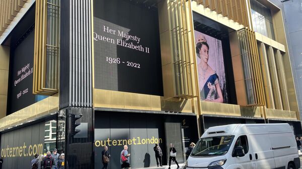 Una pantalla con la imagen de la reina Isabel II en la fachada de un edificio en una calle de Londres - Sputnik Mundo