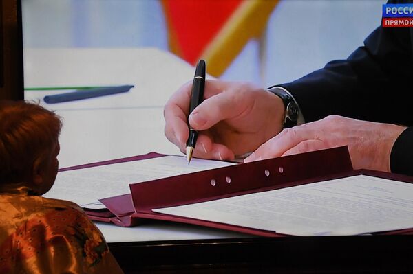Vladímir Putin firma los acuerdos sobre la incorporación de cuatro nuevas regiones al país. - Sputnik Mundo