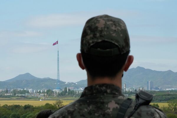 El 4 de octubre, el Ejército norcoreano lanzó un misil balístico que sobrevoló Japón y cayó en el océano Pacífico, fuera de su zona económica exclusiva. El misil recorrió unos 4.600 km, la máxima distancia de cualquier prueba realizada por la RPDC.En la foto: un soldado surcoreano en la aldea de Panmunjom, en la zona desmilitarizada. En el fondo, una bandera de la RPDC. - Sputnik Mundo
