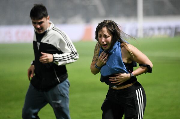 Dos hinchas en el estadio de La Plata, en Argentina, afectados por los gases lacrimógenos utilizados por la Policía para contener a los espectadores clandestinos que intentaron irrumpir sin entradas en un partido Gimnasia contra Boca. - Sputnik Mundo