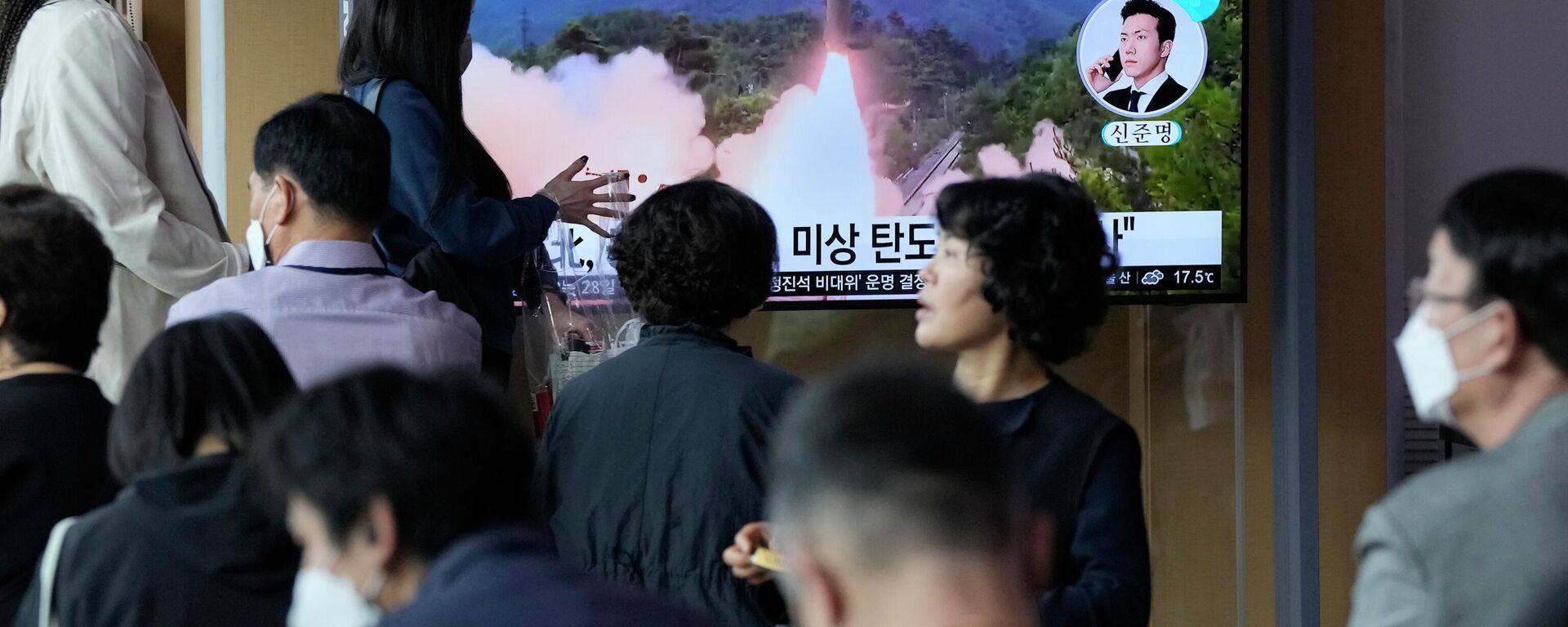 Un grupo de personas observa un programa de noticias que muestra una imagen de archivo del lanzamiento de un misil por parte de Corea del Norte - Sputnik Mundo, 1920, 19.12.2022