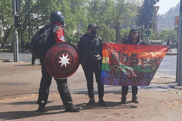Manifestantes marchan por el tercer aniversario del estallido social con una bandera que dice nos están matando - Sputnik Mundo