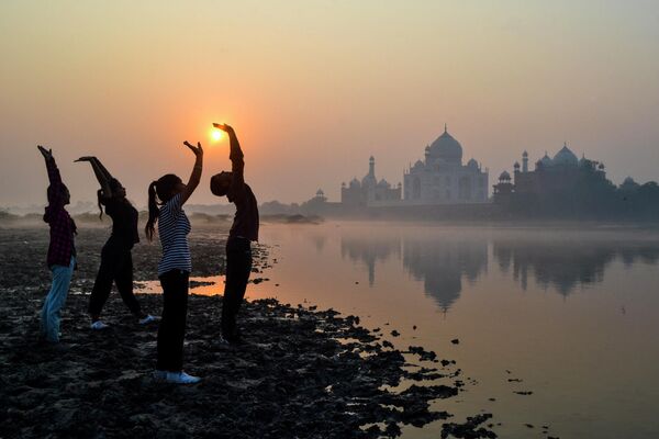 Unos niños realizan ejercicios gimnásticos al amanecer a orillas del río Yamuna, cerca del mausoleo del Taj Mahal, en Agra, al norte de la India. - Sputnik Mundo