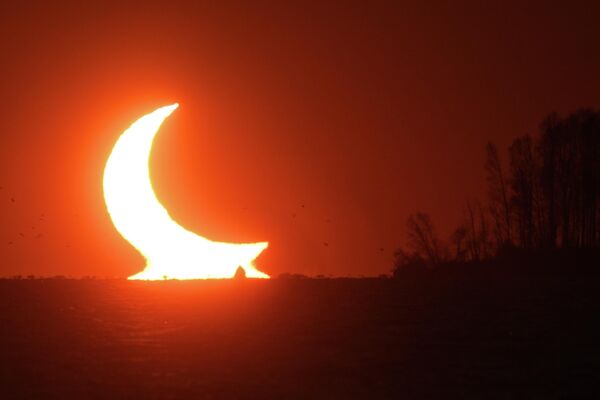 Un eclipse solar parcial, visto al atardecer cerca de Novosibirsk en Siberia Occidental, Rusia. - Sputnik Mundo