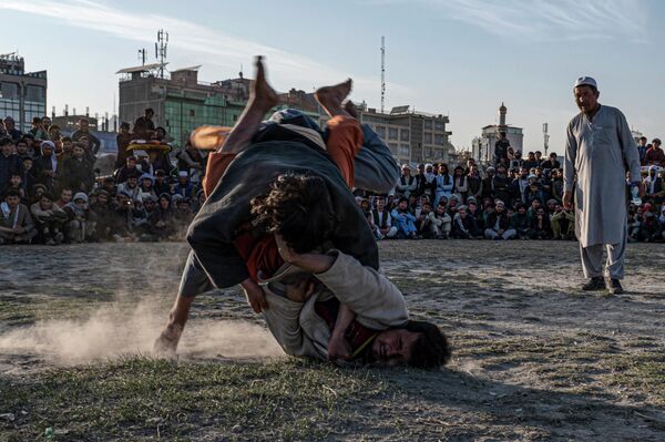 Participantes en una competición de lucha tradicional afgana en un campo de la zona de Chaman-e-Huzuri, en Kabul. - Sputnik Mundo