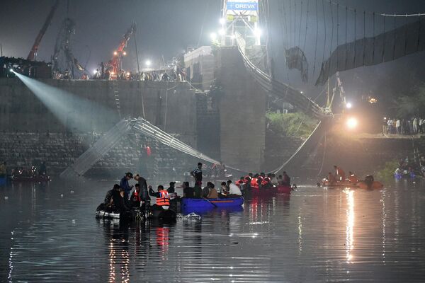 Personal de rescate indio lleva a cabo operaciones de búsqueda tras el derrumbe de un puente sobre el río Machchhu en la ciudad india de Morbi. - Sputnik Mundo